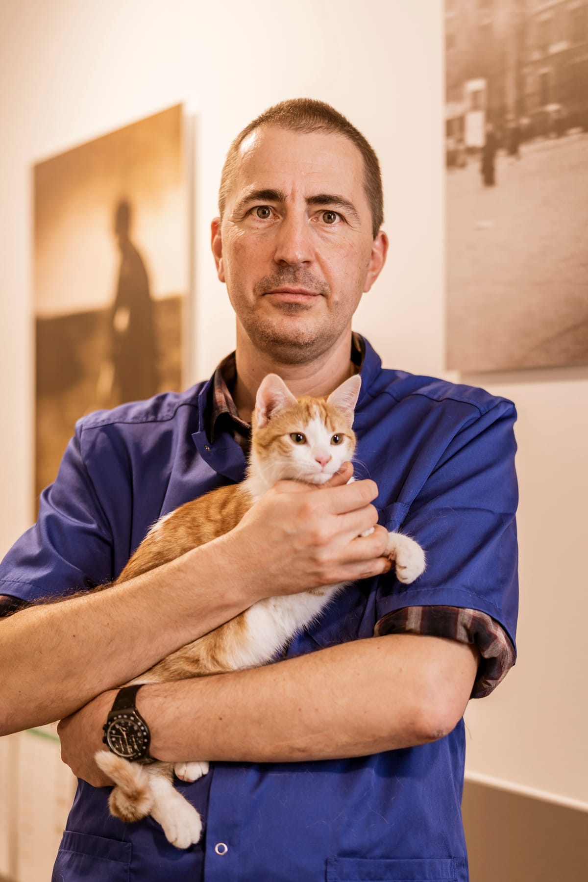 Oprichter Dieter Verdonck in blauwe scrub met een rood-witte kat in zijn armen